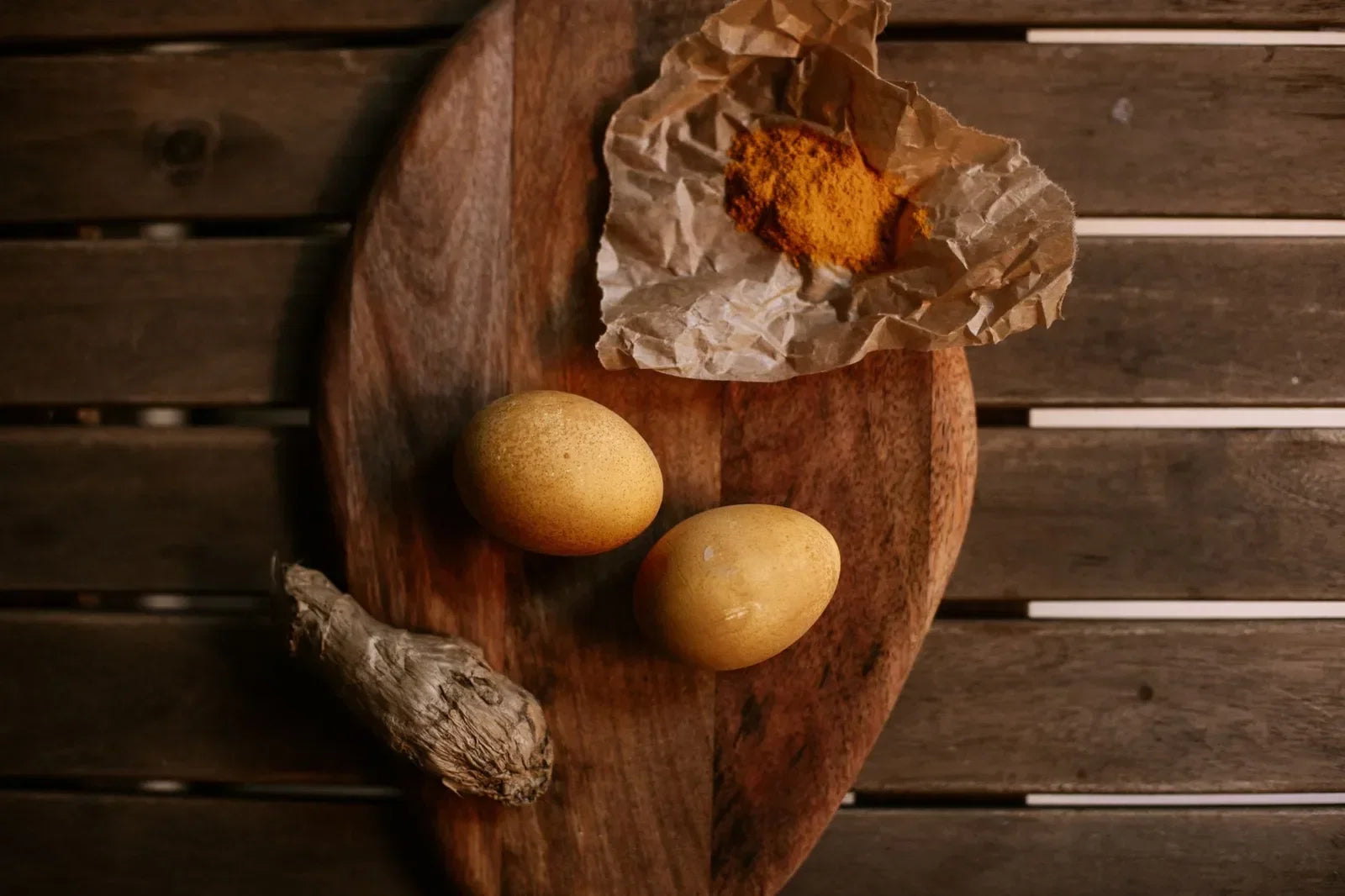 Small bowls of turmeric, ground ginger, and smoked salt on a wooden board