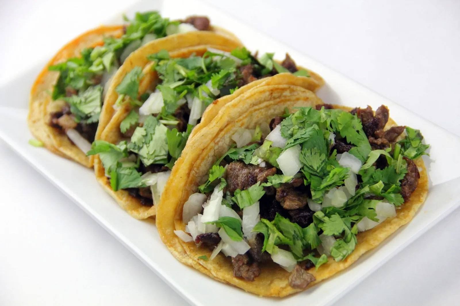 Plated tacos with seasoned ground beef and fresh herbs