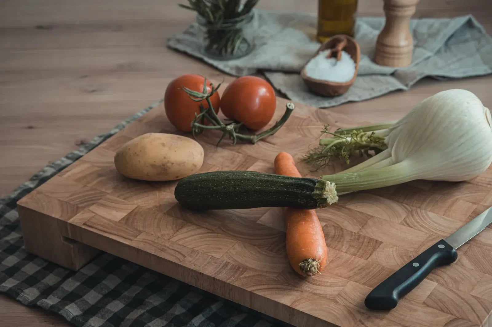 Fresh tarragon and a sliced fennel bulb with fronds on a wooden board